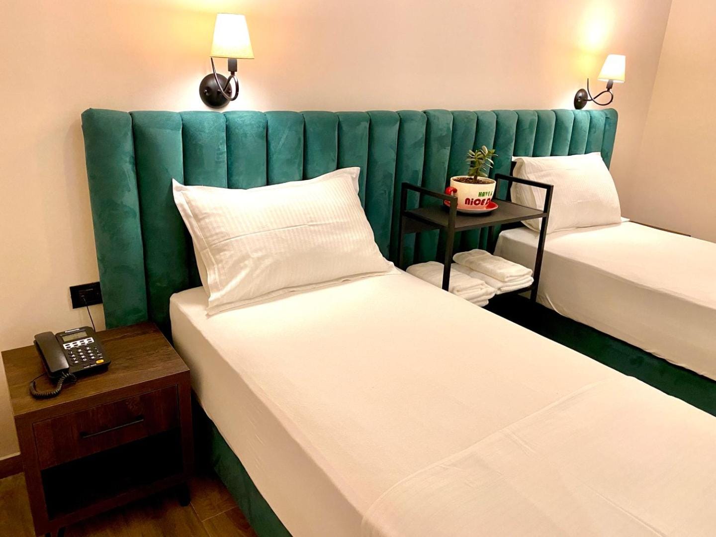 Twin beds with a green velvet headboard