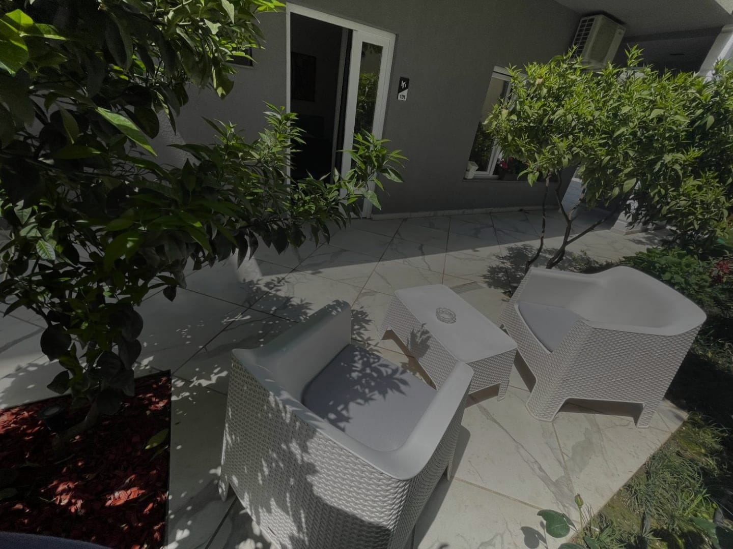White armchairs under the trees in the courtyard