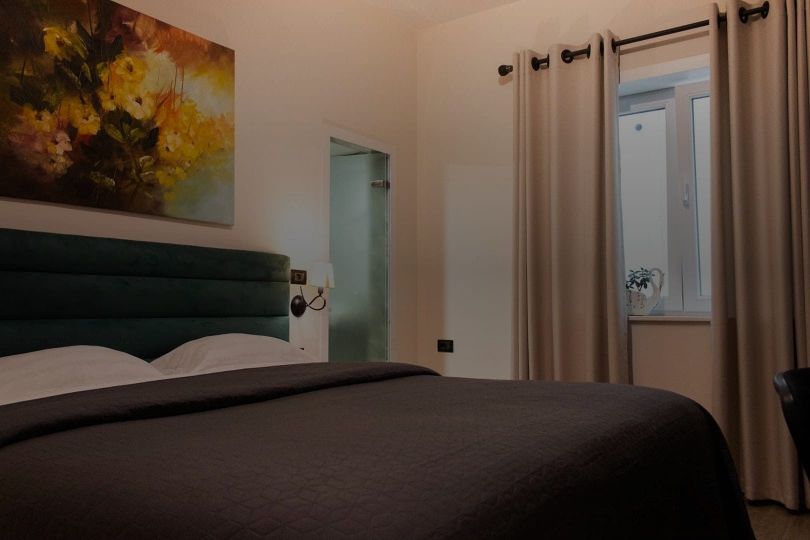 A room with a green velvet headboard